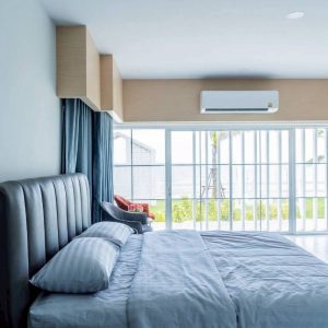 ห้องนอนเตียงใหญ่พร้อมวิวทะเลและประตูกระจกในบ้านพักพูลวิลล่ากุยบุรี